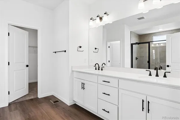 a bathroom with a double vanity sink and mirror