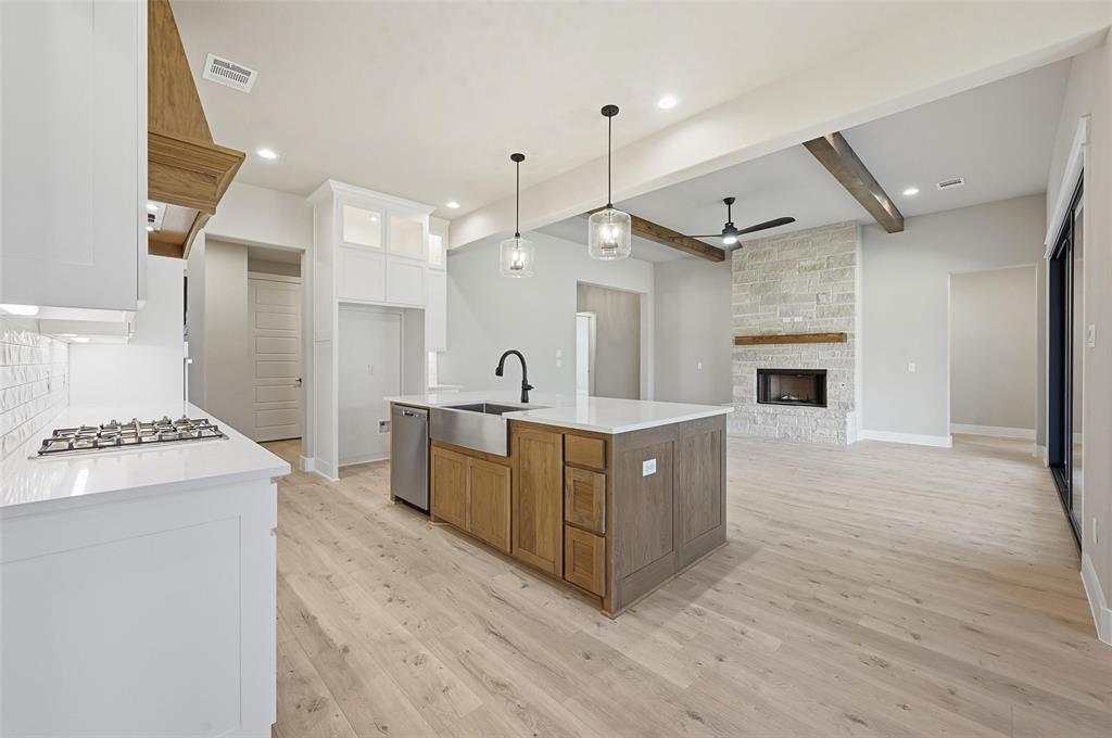 1053 Llano Way Poolville, TX 76487 - Photo 16 of 40 a large kitchen with a stove top oven a sink a counter space and wooden floor