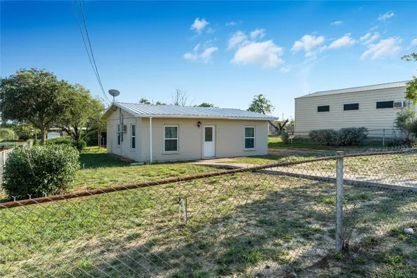 a view of a house with backyard and sitting area