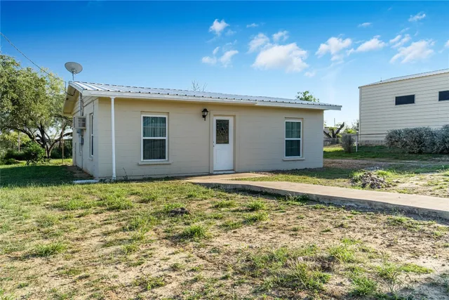 a view of a house with backyard and swimming pool