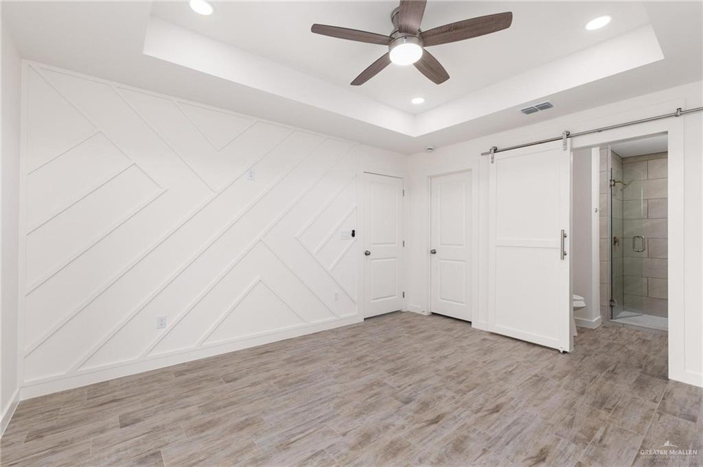 349 Barcelona Street Donna, TX 78537 - Photo 12 of 19 an empty room with wooden floor ceiling fan and windows