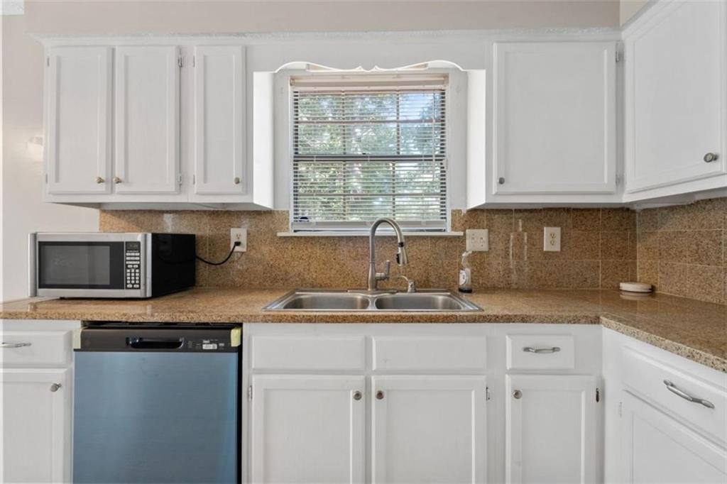 7519 Conkle Road Jonesboro, GA 30236 - Photo 11 of 35 a kitchen with granite countertop a sink window and cabinets