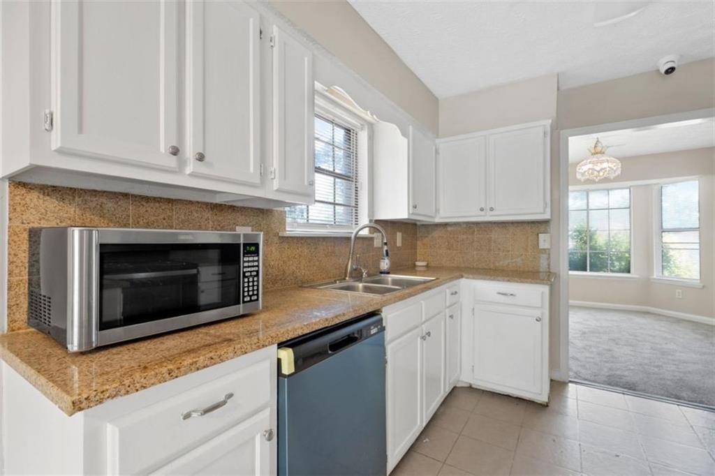 7519 Conkle Road Jonesboro, GA 30236 - Photo 12 of 35 a kitchen with granite countertop white cabinets and a sink