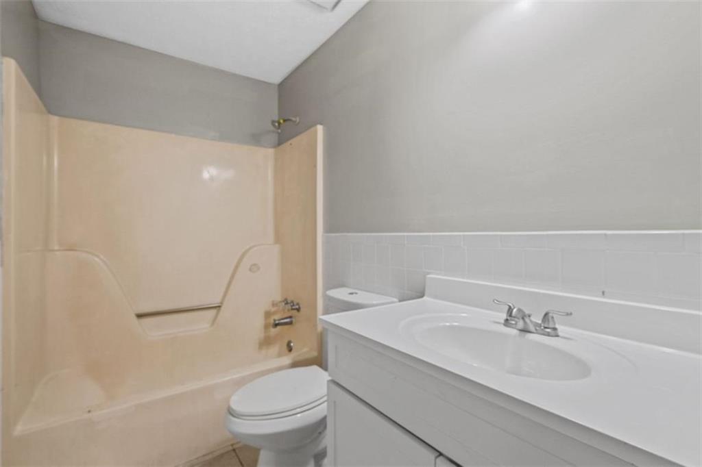 7519 Conkle Road Jonesboro, GA 30236 - Photo 14 of 35 a bathroom with a granite countertop sink toilet and shower