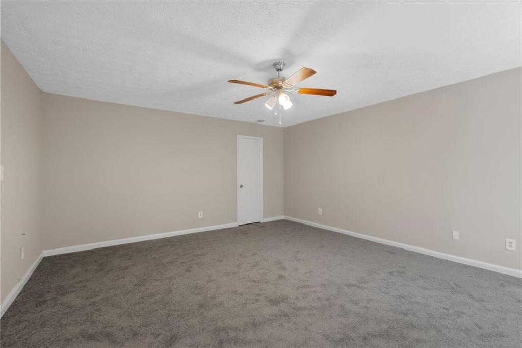 7519 Conkle Road Jonesboro, GA 30236 - Photo 21 of 35 an empty room with windows and chandelier fan