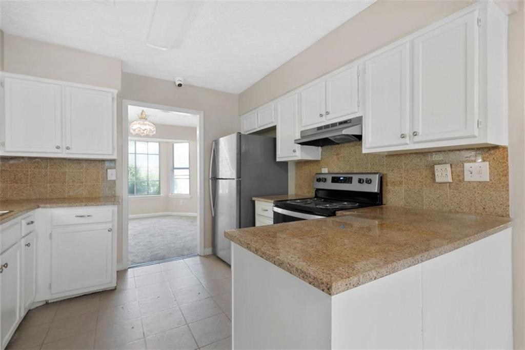 7519 Conkle Road Jonesboro, GA 30236 - Photo 10 of 35 a kitchen with stainless steel appliances granite countertop a stove a sink and a refrigerator