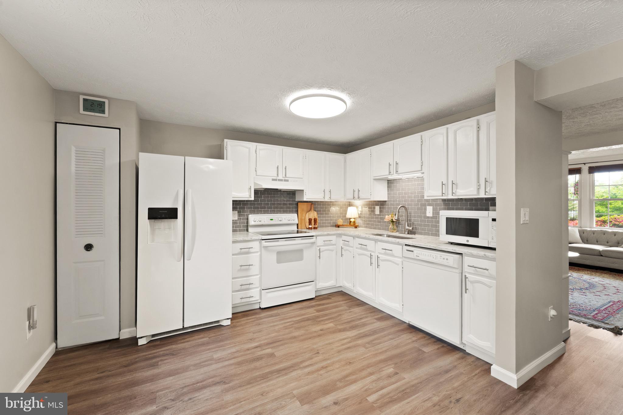 1617 Sierra Woods Drive Reston, VA 20194 - Photo 13 of 39 a kitchen with white cabinets and stainless steel appliances