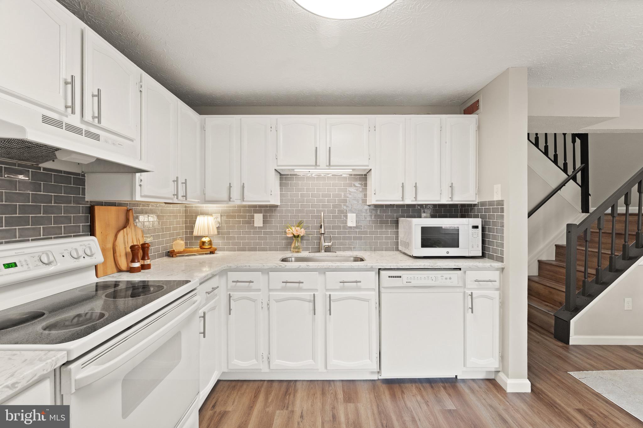 1617 Sierra Woods Drive Reston, VA 20194 - Photo 14 of 39 a kitchen with granite countertop a sink a stove and cabinets