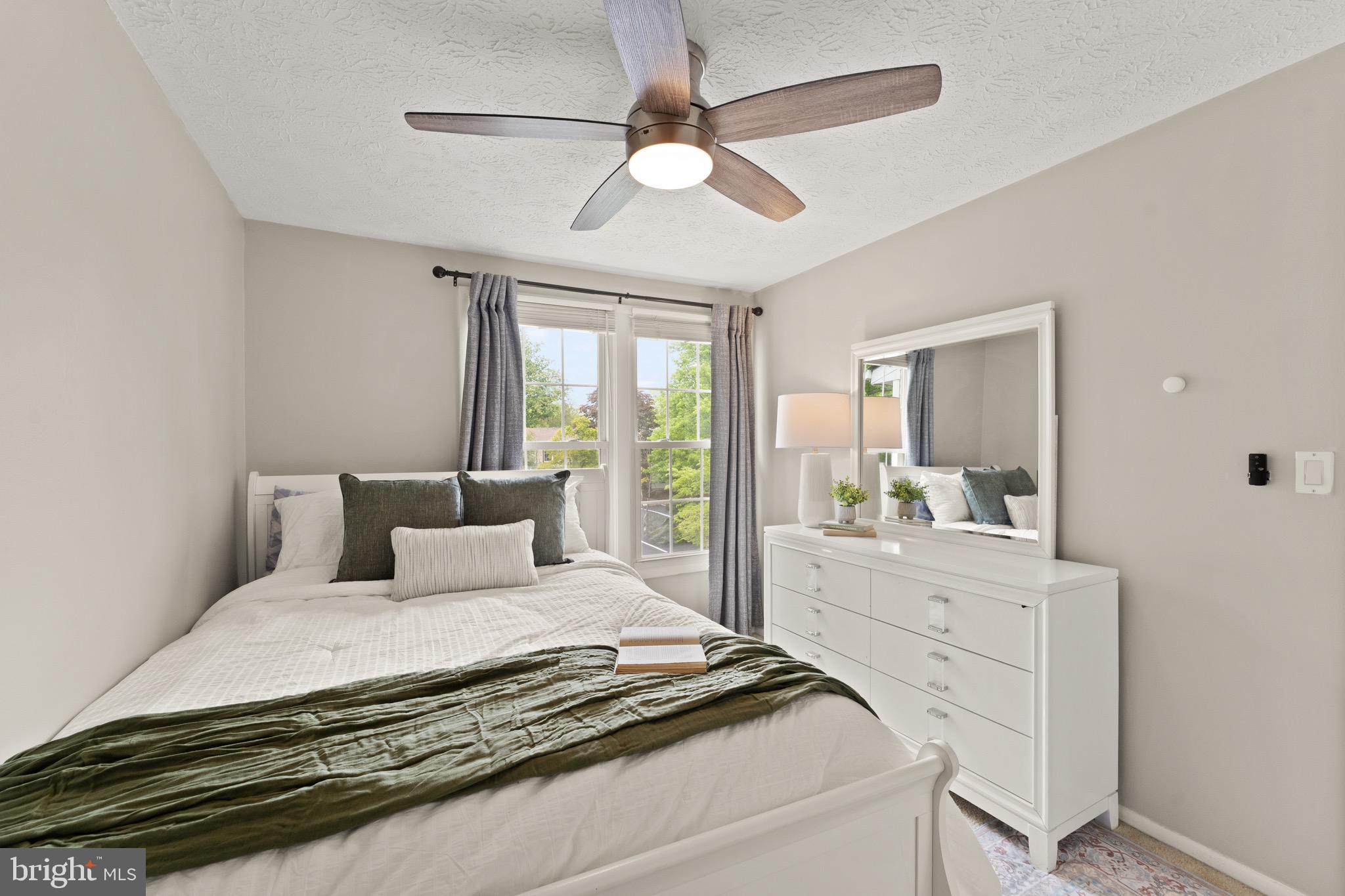 1617 Sierra Woods Drive Reston, VA 20194 - Photo 31 of 39 a bedroom with a large bed and a chandelier fan