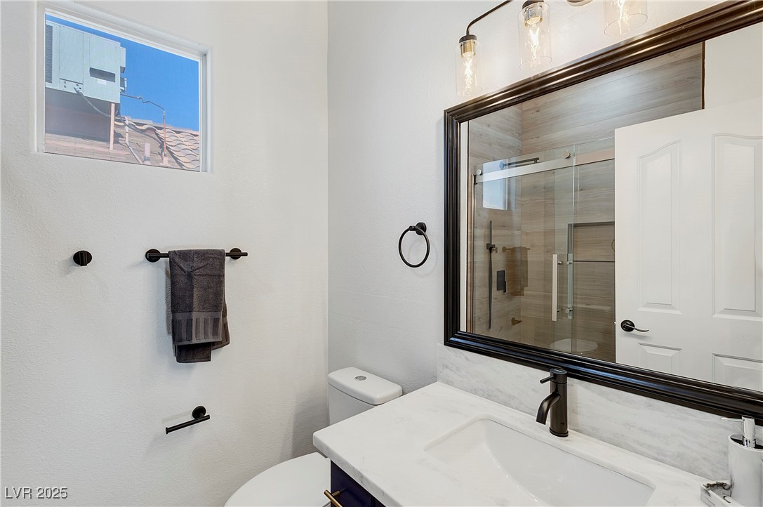 9156 Sapphire Point Avenue Las Vegas, NV 89147 - Photo 11 of 18 Bathroom featuring a shower with door, toilet, and