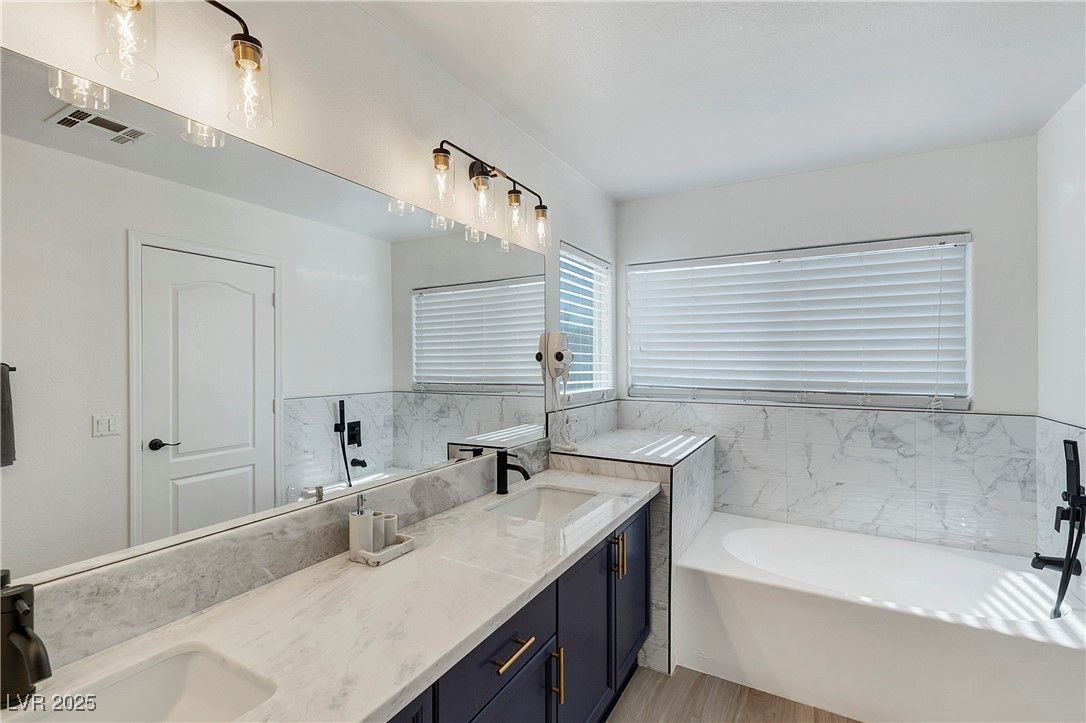 9156 Sapphire Point Avenue Las Vegas, NV 89147 - Photo 15 of 18 Bathroom with visible vents, a garden tub, double