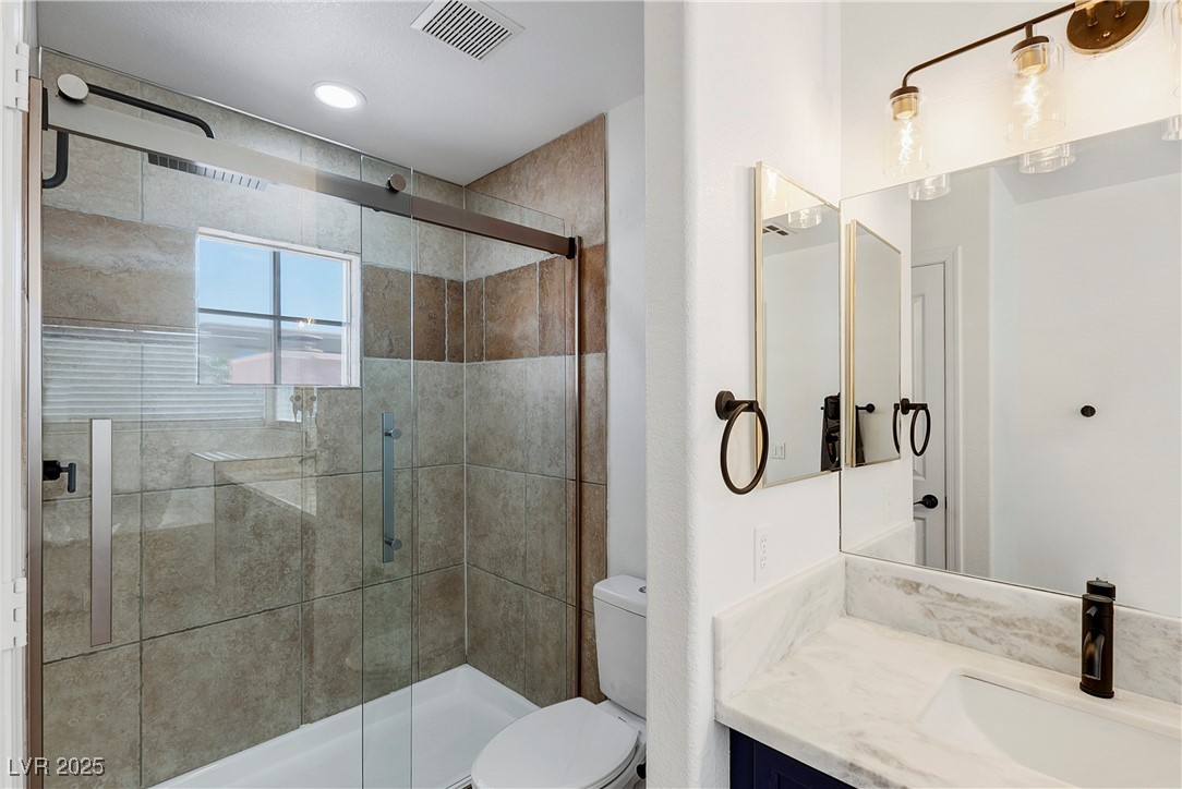 9156 Sapphire Point Avenue Las Vegas, NV 89147 - Photo 16 of 18 Bathroom featuring toilet, visible vents, a shower