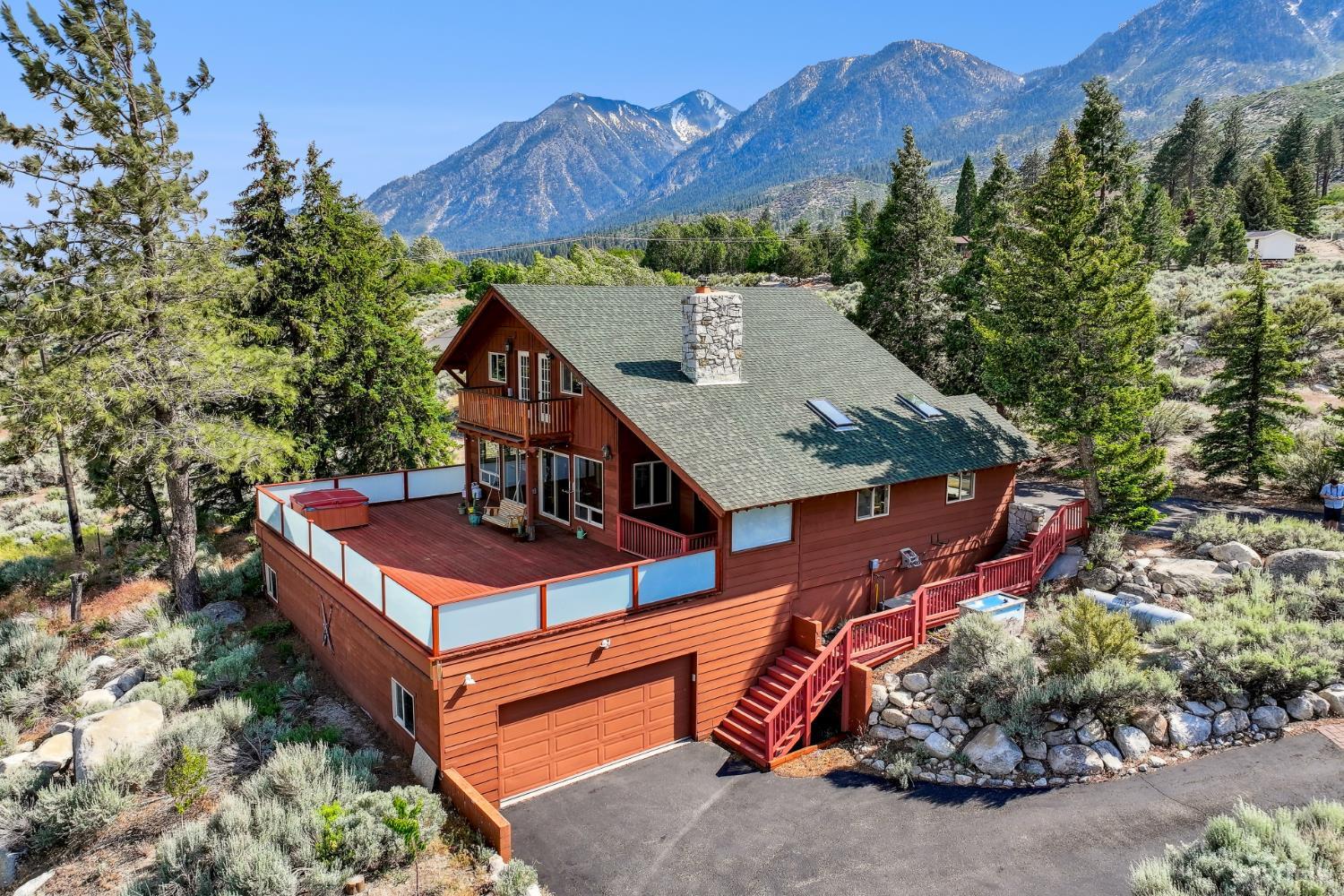 an aerial view of a house with balcony and trees all around