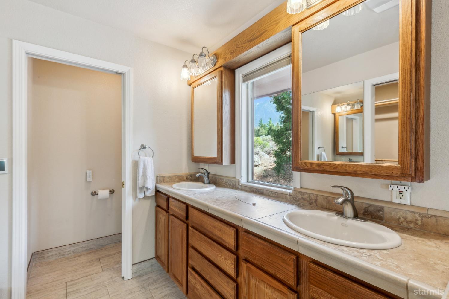 1299 Kingsbury Grade Road Gardnerville, NV 89460 - Photo 21 of 37 a bathroom with a granite countertop sink and a mirror