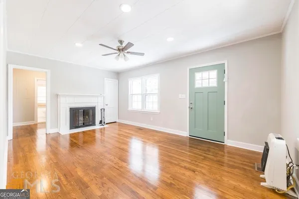 a view of an empty room with a window and fireplace