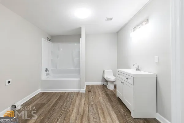 a bathroom with a sink and mirror with bathtub