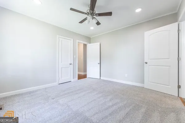 an empty room with windows and fan