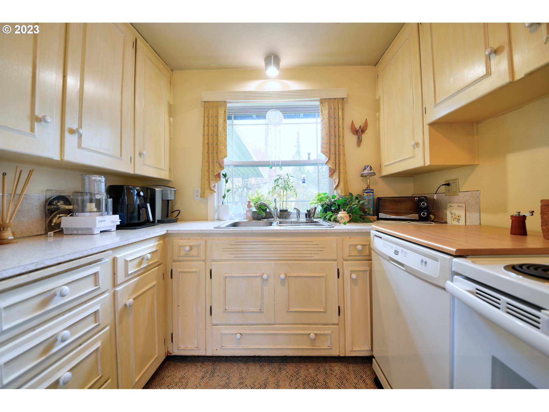 1267 N Street Springfield, OR 97477 - Photo 9 of 27 a kitchen with white cabinets and window