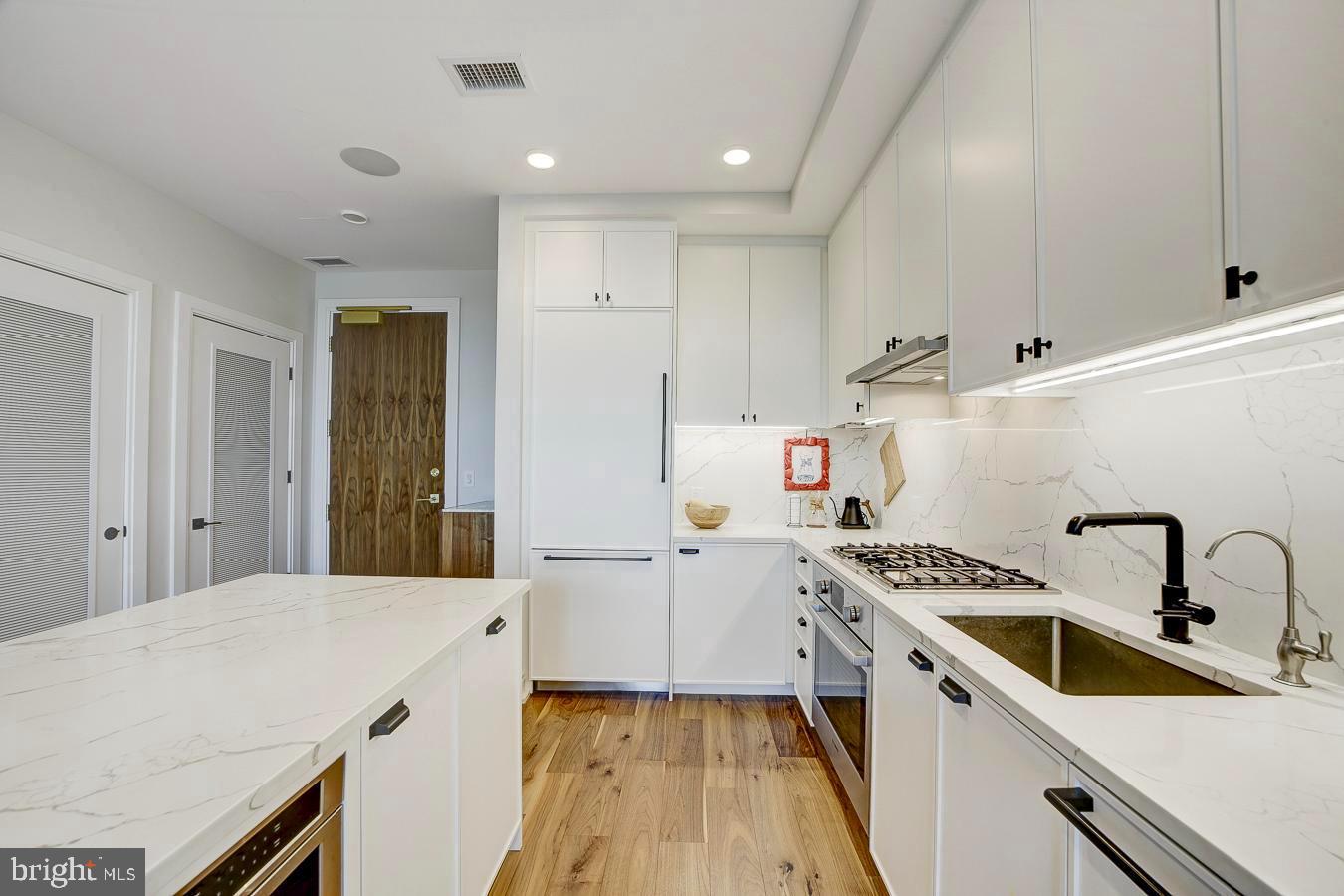 1111 Pennsylvania Ave. Southeast, Unit 409 Washington, DC 20003 - Photo 11 of 26 a kitchen that has a sink and a stove in it