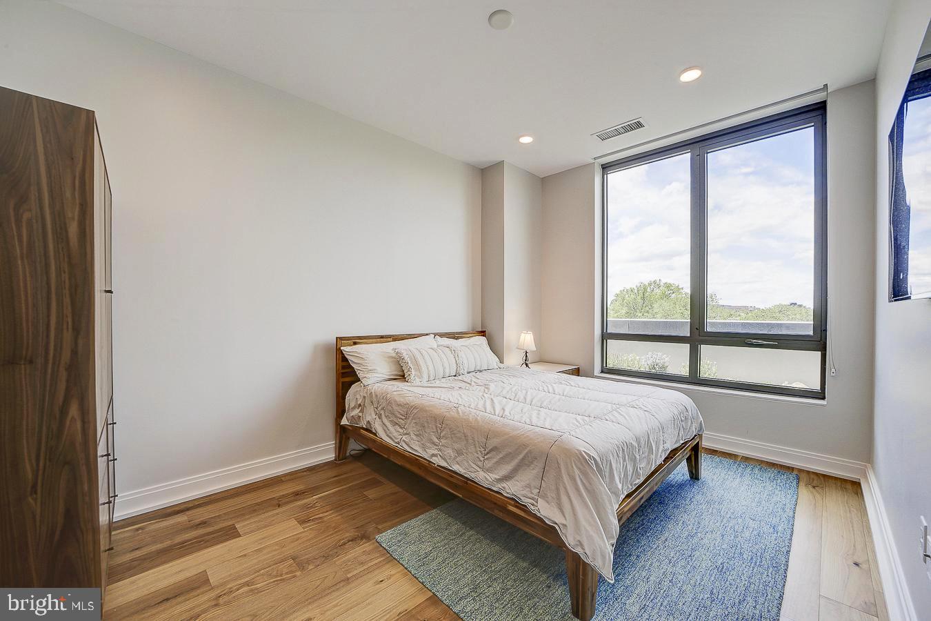 1111 Pennsylvania Ave. Southeast, Unit 409 Washington, DC 20003 - Photo 12 of 26 a bed sitting in a spacious bedroom next to a window