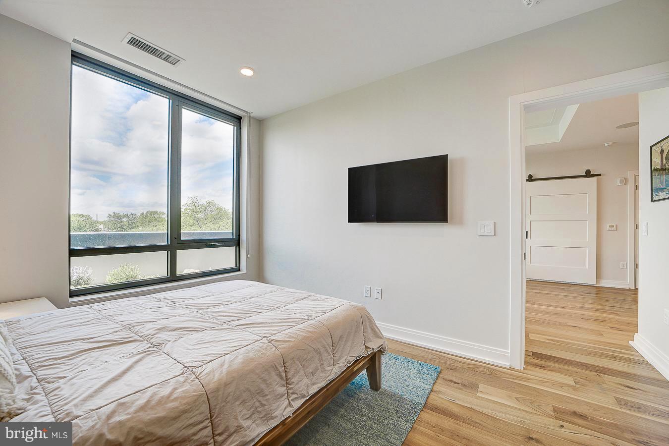 1111 Pennsylvania Ave. Southeast, Unit 409 Washington, DC 20003 - Photo 13 of 26 a bedroom with a bed and a flat screen tv