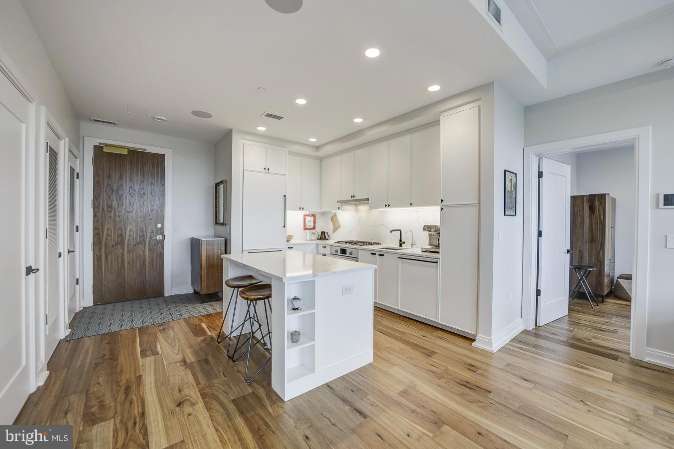 1111 Pennsylvania Ave. Southeast, Unit 409 Washington, DC 20003 - Photo 8 of 26 a living room with stainless steel appliances kitchen island hardwood floor and a view of kitchen