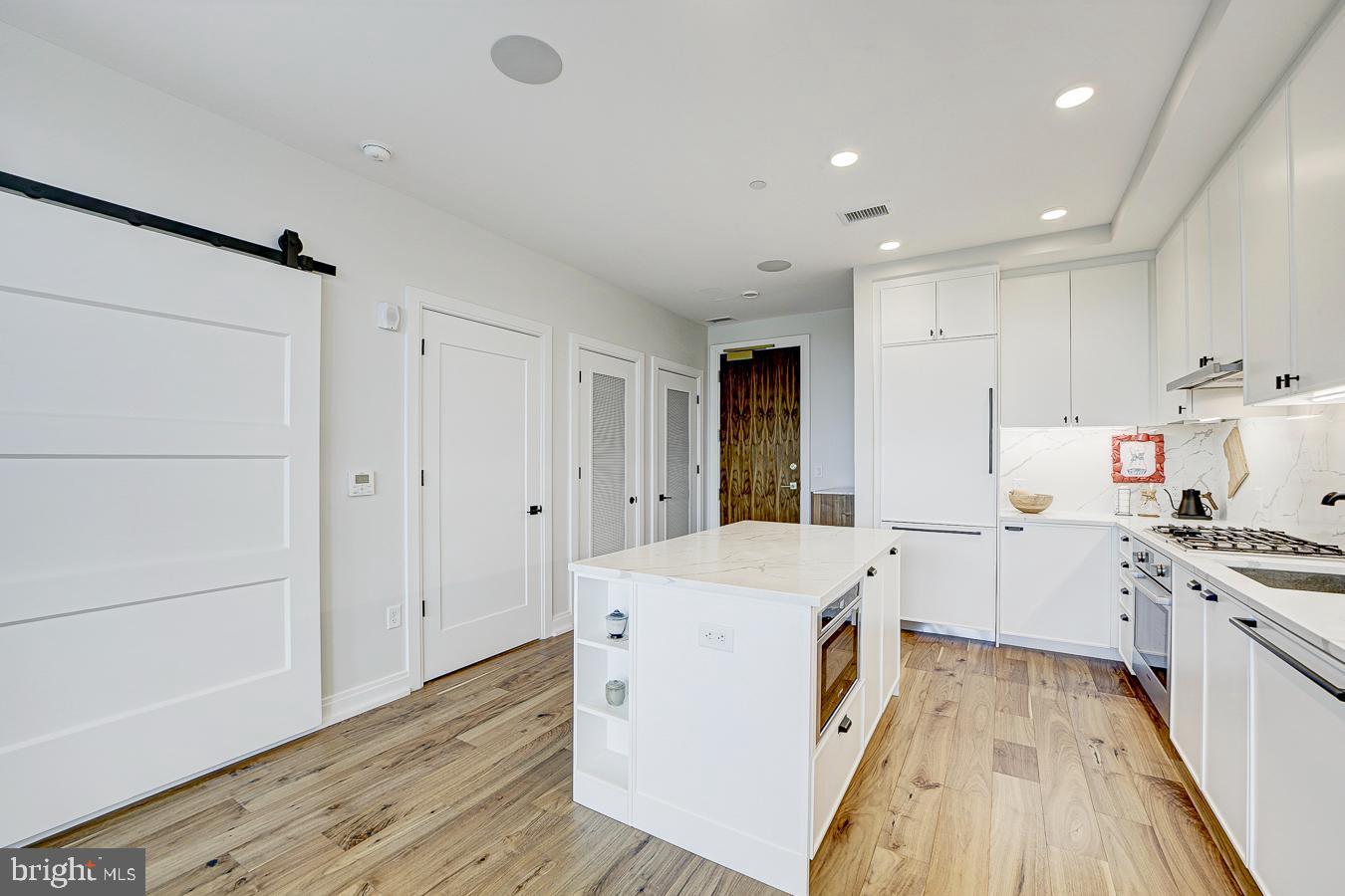 1111 Pennsylvania Ave. Southeast, Unit 409 Washington, DC 20003 - Photo 9 of 26 a kitchen with a sink a stove and cabinets