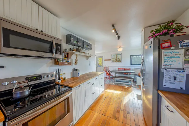 a kitchen with stainless steel appliances a stove sink microwave and cabinets
