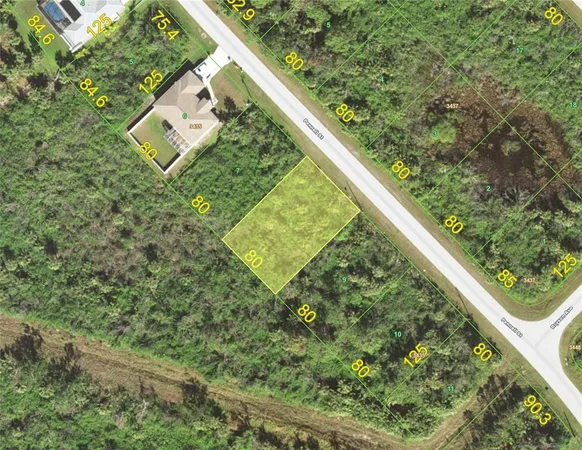 a view of a yard with plants and wooden fence