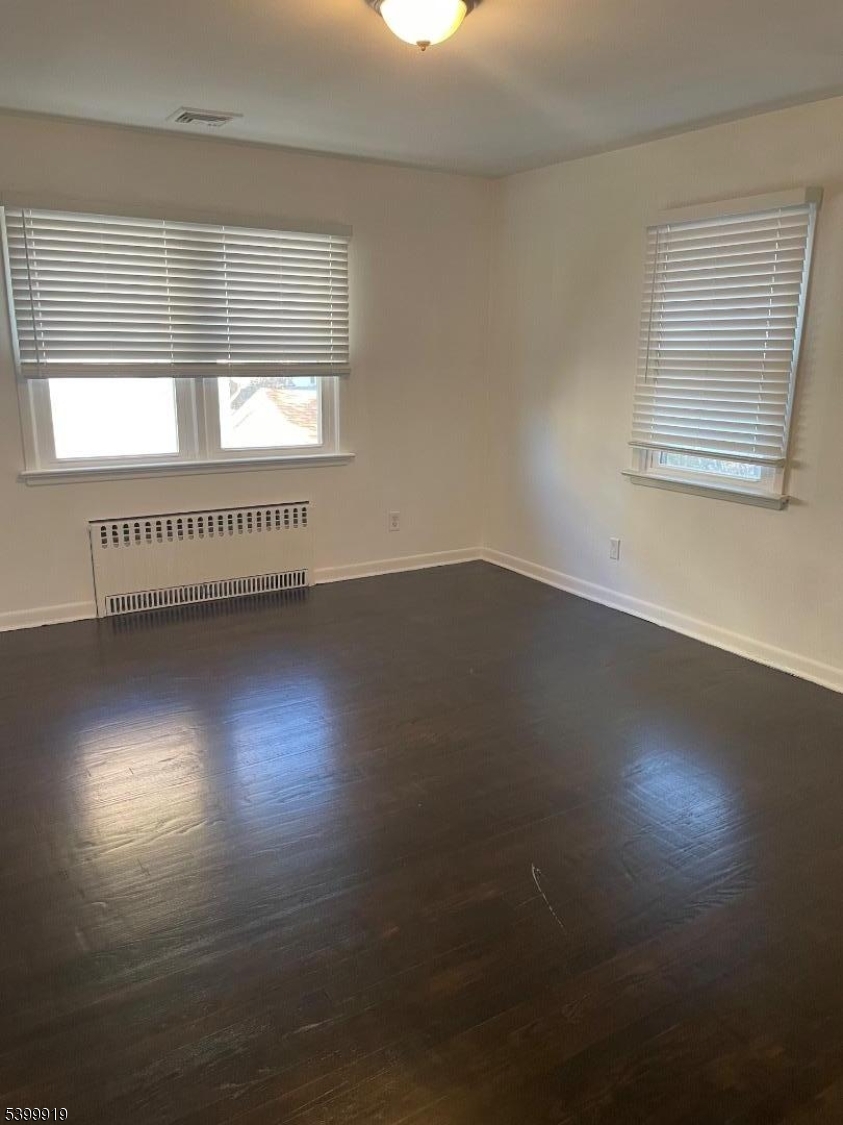 113 Hawthorne Avenue, Unit 2 Hawthorne, NJ 07506 - Photo 17 of 18 an empty room with wooden floor and windows
