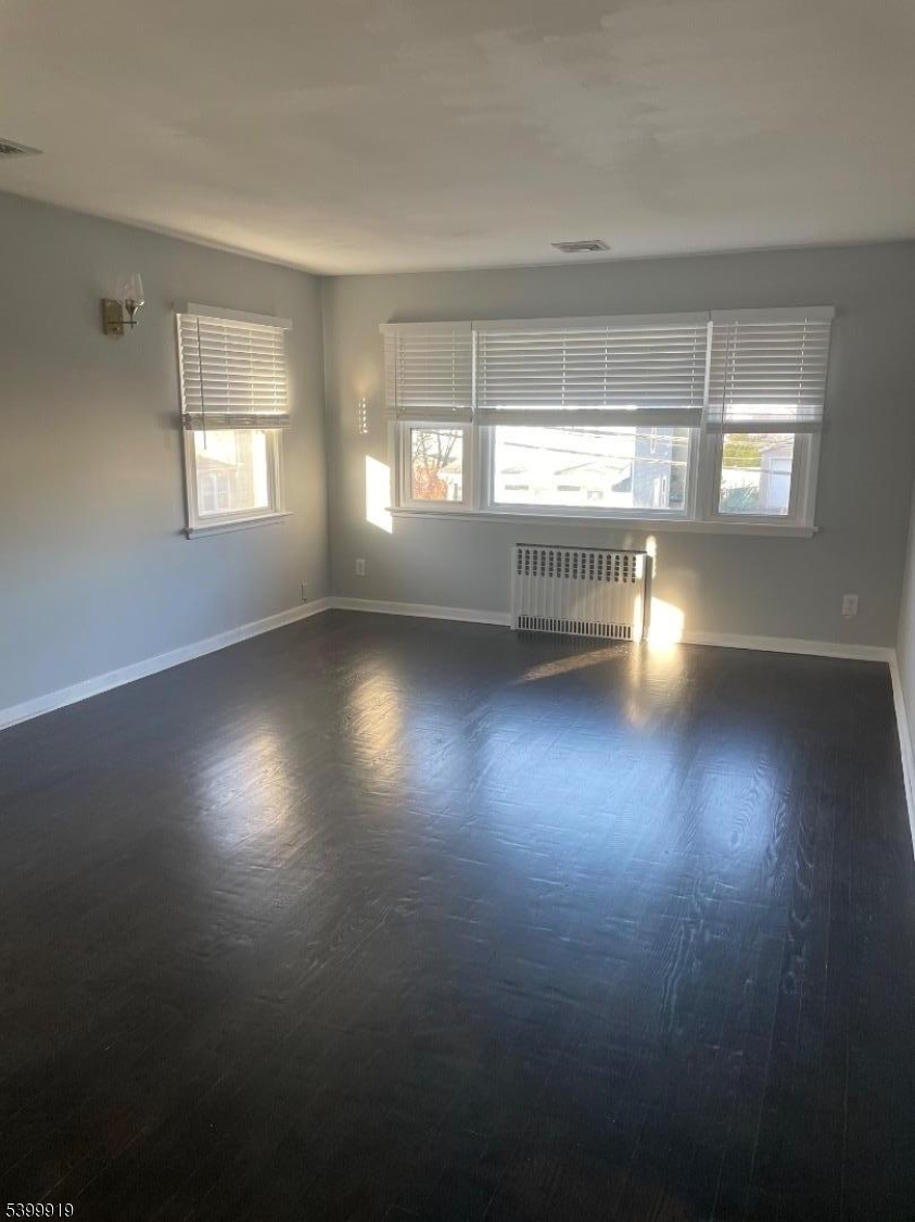 113 Hawthorne Avenue, Unit 2 Hawthorne, NJ 07506 - Photo 3 of 18 an empty room with wooden floor and windows