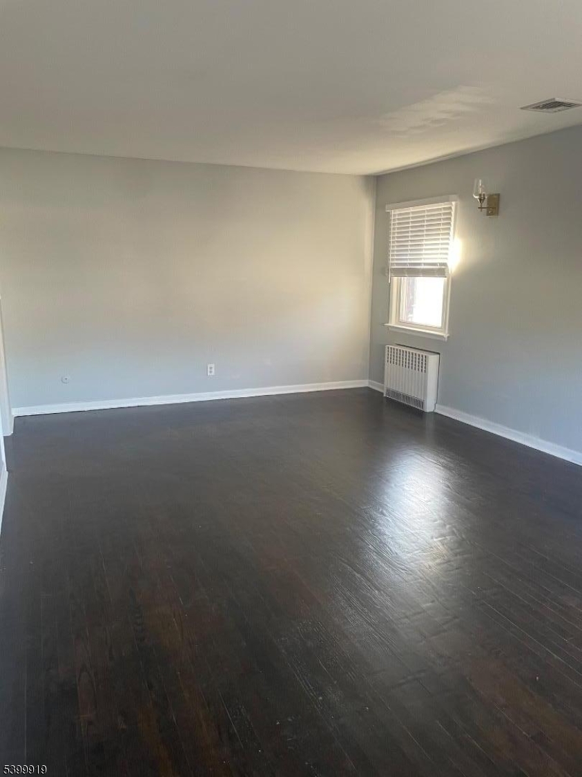 113 Hawthorne Avenue, Unit 2 Hawthorne, NJ 07506 - Photo 4 of 18 an empty room with wooden floor and windows