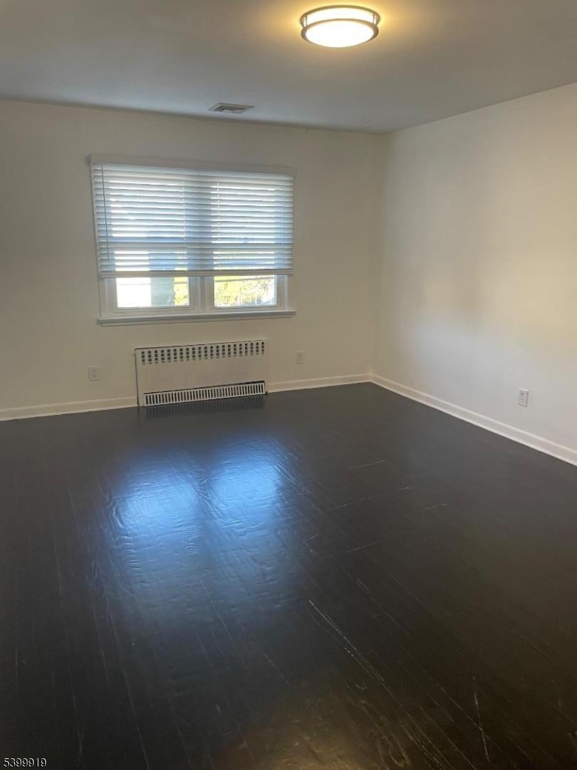 113 Hawthorne Avenue, Unit 2 Hawthorne, NJ 07506 - Photo 10 of 18 a view of an empty room with wooden floor and a window