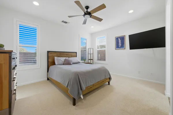 a spacious bedroom with a bed and a flat screen tv