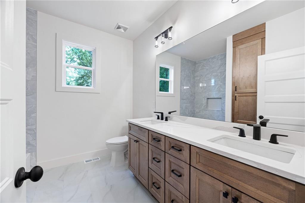114 Folsom Road Northwest Adairsville, GA 30103 - Photo 12 of 20 a bathroom with a double vanity sink a mirror and a toilet