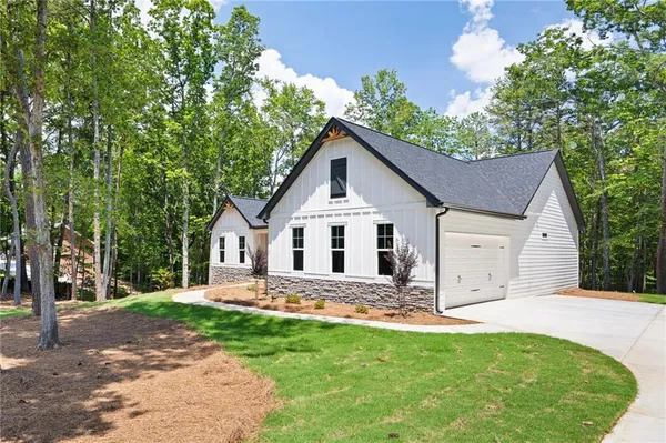 a front view of a house with a yard and trees