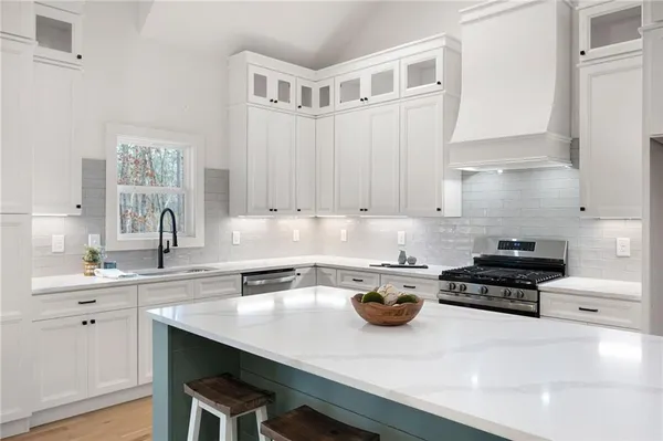 a kitchen with a sink a stove and cabinets