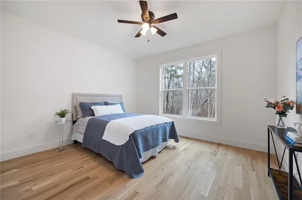 a spacious bedroom with a bed and wooden floor