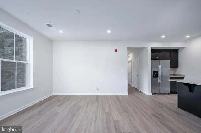 a large kitchen with stainless steel appliances a large counter top a stove a refrigerator and a sink