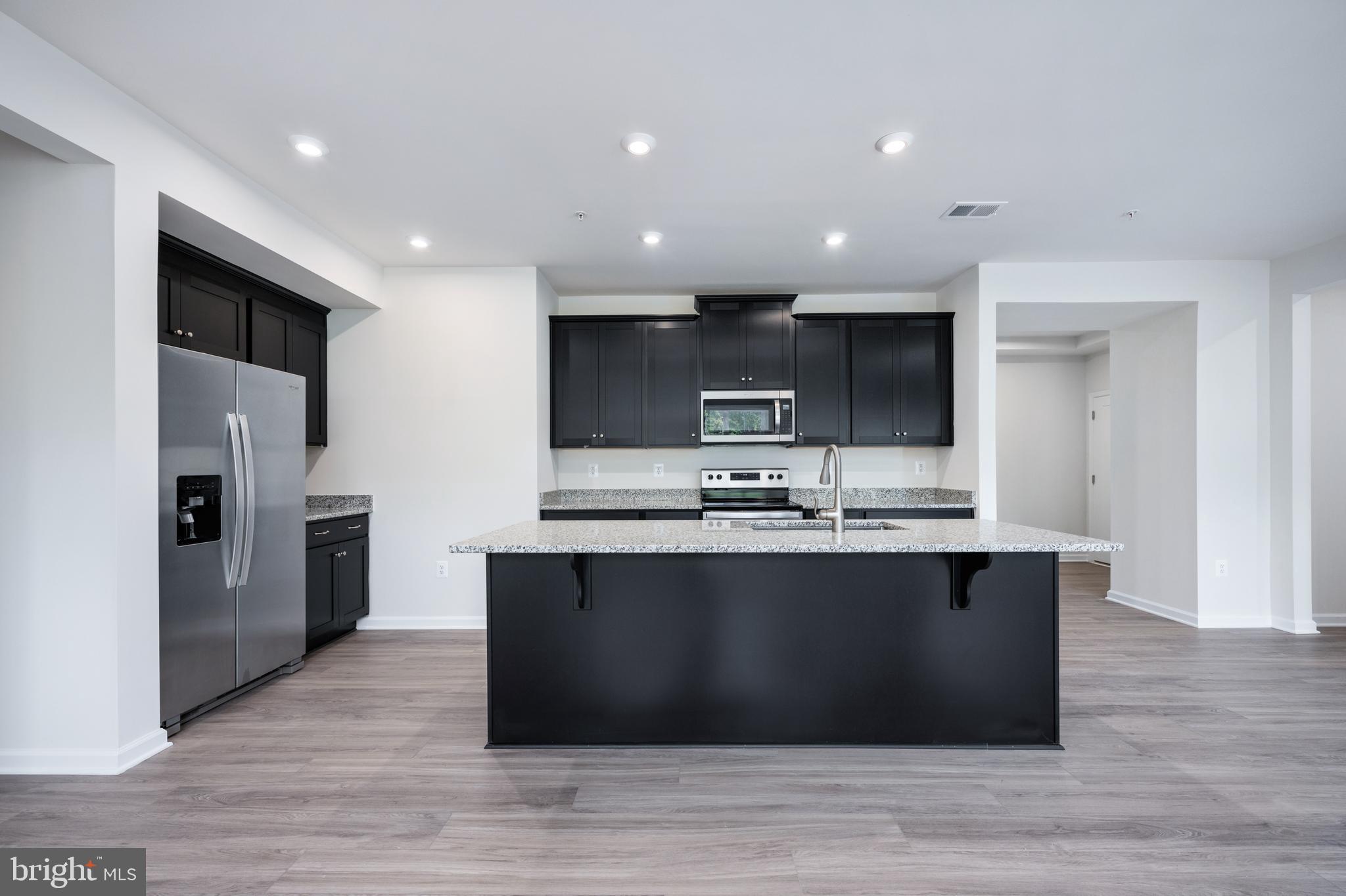 29 Hyssop Way, Unit 101 Stafford, VA 22554 - Photo 14 of 34 a large kitchen with stainless steel appliances a large counter top a stove a refrigerator and a sink
