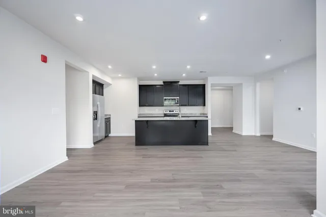 a kitchen with stainless steel appliances kitchen island granite countertop a stove a sink and a refrigerator