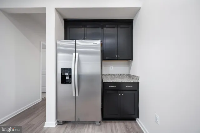 a kitchen with stainless steel appliances granite countertop a sink a stove top oven and wooden floor