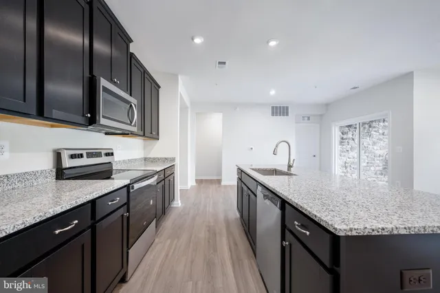 a kitchen with a sink a window and a wooden floor
