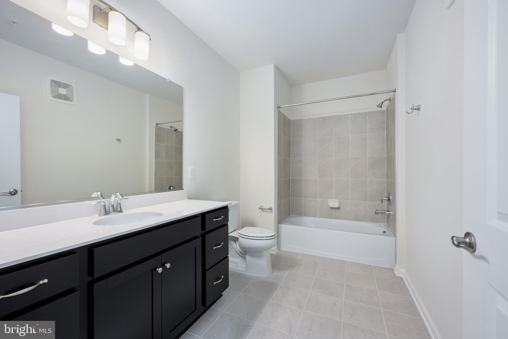 29 Hyssop Way, Unit 101 Stafford, VA 22554 - Photo 25 of 34 a bathroom with a double vanity sink toilet mirror and bathtub