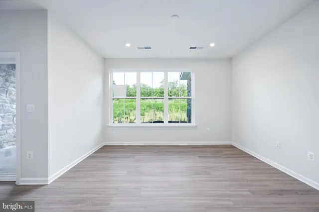a view of a hallway with wooden walls and a window