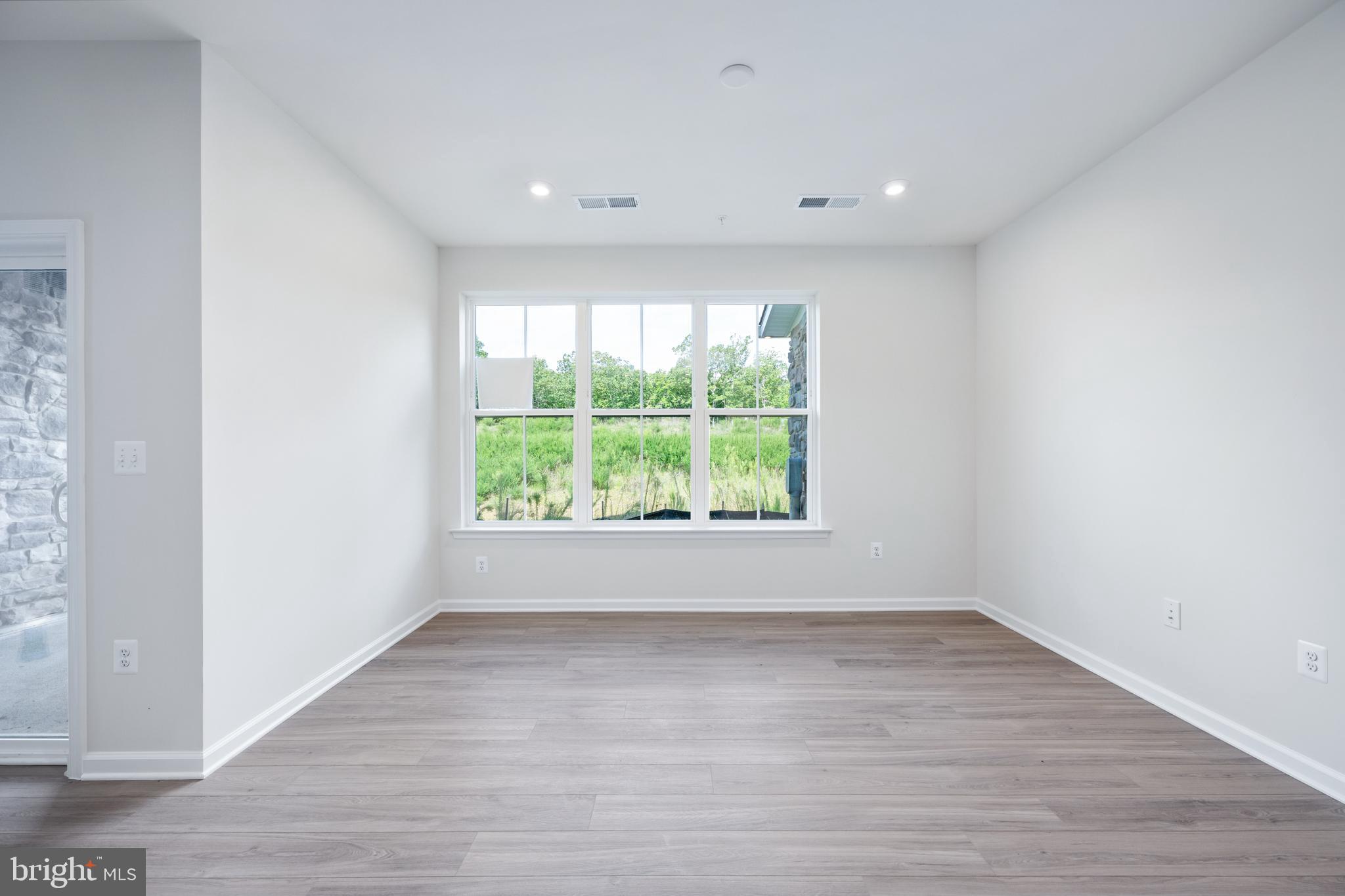 29 Hyssop Way, Unit 101 Stafford, VA 22554 - Photo 7 of 34 a view of an empty room with wooden floor and a window