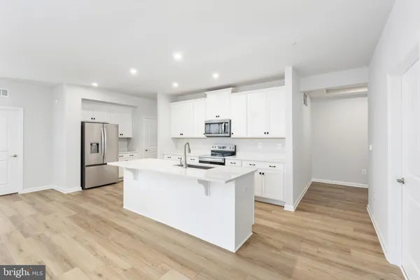a kitchen with stainless steel appliances granite countertop a sink a stove and a refrigerator