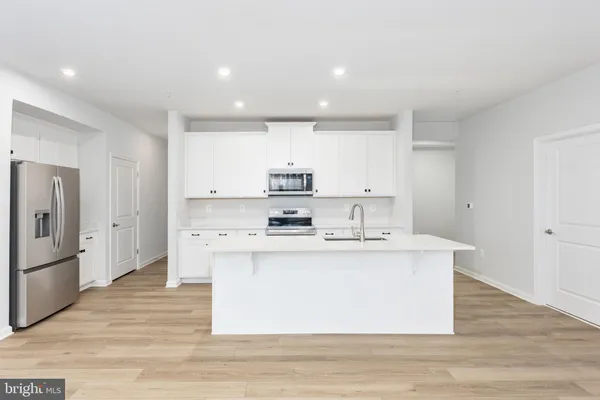 a kitchen with stainless steel appliances a white stove top oven sink and cabinets
