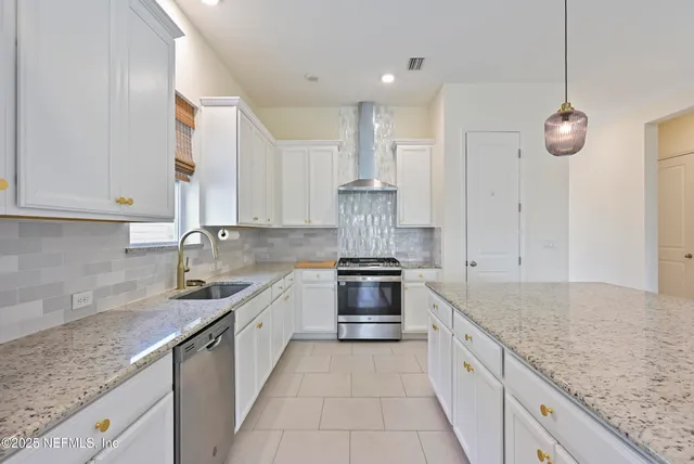 a kitchen with stainless steel appliances granite countertop a sink and a wooden floor