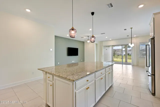 a kitchen with stainless steel appliances granite countertop a stove a sink a center island a counter top space cabinets and a wooden floor